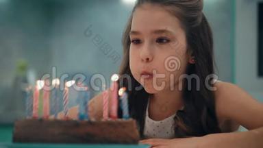 慢动作吹蜡烛的女孩肖像。 儿童生日快乐概念